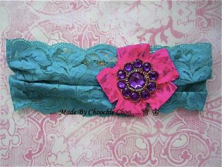 Green wide lace hair band, with a pink lace flower and purple diamante 