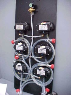 Flojet 5000 series syrup pumps mounted on a pump board with a 